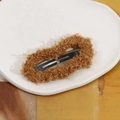 Close-up of caramel brown plush fabric texture on a matte black metal hair clip - Brown