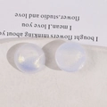 Close-up of sparkling round iridescent acrylic cabochons with purple and gold glitter - White