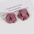 Detailed macro view of deep pink handmade satin ribbon roses for DIY hair accessories - Purple