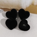 Gros plan de breloques en forme de cœur floqué noir avec trou pour la création de bijoux - Noir