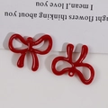 Detail von zwei glänzenden roten Schleifenanhängern für DIY-Schmuck mit Aufhängeloch - Schleife (Mit Loch) / Rot