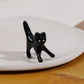 Dettaglio ravvicinato di un accessorio a forma di gatto nero 3D su un piatto bianco - Gatto Nero