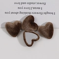 Close-up of four brown velvet heart buttons with metal backing for DIY fashion sewing - Brown