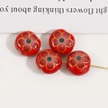 Macro shot of 12mm red floral ceramic beads with hand-painted gold detail for DIY jewelry - Red