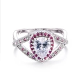 Dettaglio anello con zircone a pera, alone rosa e fascia incrociata in metallo bianco - US 5 / Platino