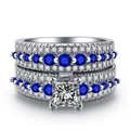 Detailed macro view of white gold plated rings with blue sapphire and micro zircon inlay - US 5