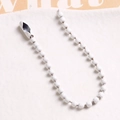 Macro detail of white painted metal bead chain with connector for DIY crafts and hanging - White
