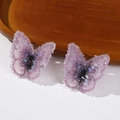 Close-up of pink-purple gradient fabric butterfly with glittering rhinestones and beads - Purple