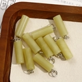 Macro detail of ten light green natural stone cylinder pendants for DIY jewelry making - Light Green Jade Style (No. 14)