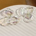 Macro shot of iridescent AB colored acrylic three-petal flower beads on a white tray - Iridescent AB Color Three-Petal Flower