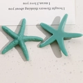 Macro view of ocean series teal starfish resin charms with matte and glossy textures - Blue