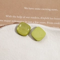 Détail de boucles d'oreilles carrées en résine vert olive sur un plateau en céramique - Carré Vert