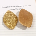 Detail of amber diamond-shaped resin charms with glitter and hammered textures on a ceramic plate - Leaf Shape / Rhombus (Yellow) / Light Yellow