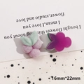Macro view of purple flocked floral and berry DIY jewelry charms on a patterned background - Flocked Grape