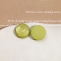 Macro shot of lime green pearlescent resin cabochons on a white textured ceramic dish - Green Round
