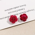 Detalle de pendientes de rosas de terciopelo rojo y metal sobre tarjeta vintage - Rosa Roja
