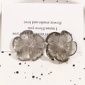Macro detail of translucent gray resin flower charms with delicate vein texture - Gray