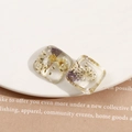 Détail macro de boucles d'oreilles carrées en résine avec fleurs séchées et perles - Patch Carré Fleur Séchée Perle