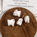 Süße weiße beflockte Kaninchenperlen für DIY-Schmuck auf einem Holztablett serviert - Beflocktes Weiß