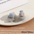 Primer plano de figuritas de patitos flocados grises con sombreros azules, 20x20mm - Pato Gris (Medio Agujero)
