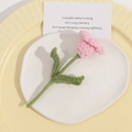 Detailed macro view of hand-knitted pink tulip flowers with green stems and leaves - One Flower