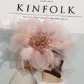 Macro detail of handmade pink mesh flower hair accessory with feathers and crystal beads - Pink