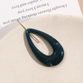Detail of dark blue marble resin hair pin with gold metal needle on beige ceramic tray - Malachite green
