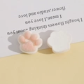 Close-up of plush resin cat paw DIY charms with pink pads on a gift card background - Orange