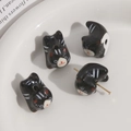 Macro-detail van handgemaakte zwart-witte keramische kattenkralen met montagepen - Zwart