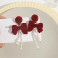 Detail of burgundy velvet bow earrings with white imitation pearl tassels on a card - Red