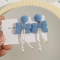Detail of blue flocked bow earrings featuring elegant dangling white pearl tassels - Blue