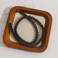 Detailed macro view of natural porous black lava stone beads for DIY jewelry making - 6.5mm Strand (Approx 63 Beads)