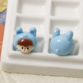 Macro view of blue cartoon rabbit girl resin charms showing front and back detail - Blue Rabbit Baby