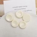 Primer plano de cinco cabujones de resina crema de 22mm con superficie cóncava para DIY - Blanco