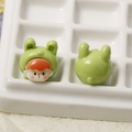 Macro shot of green cartoon girl resin charms with orange hair for DIY crafts - Green Rabbit Baby