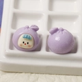 Dettaglio macro di due ciondoli in resina a forma di frutta 3D viola con faccine per DIY - Bambino Frutta Viola
