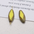 Macro shot of oval faceted glass beads with yellow centers and green mottled textures - Oval Pierced Style / 1 Piece (20x9mm) / Mottled Yellow Brown
