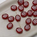 Macro view of red oval Czech glass beads with white clover pattern for DIY jewelry - 1 Piece / Red