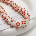 Detailed macro view of white floral glass beads for DIY necklaces and craft jewelry making - 1 Piece/Pack (10x14mm) / White