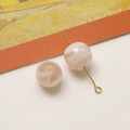 Dettaglio macro di perle di vetro marmorizzate da 12mm con perno ad anello in metallo dorato - Colore Chiaro