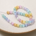 Macro shot of 8mm rainbow cat eye beads for DIY jewelry making on a white ceramic plate - 8mm Rainbow Bead Strand (Approx. 47 Beads)