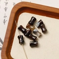 Macro shot of drum-shaped carnelian agate beads with natural white stripes on wood - Banded Agate