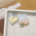 Macro view of two heart-shaped opalite stone pendants with silver-toned jump rings - Opal Heart