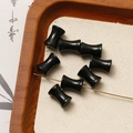 Macro detail of black drum-shaped beads with green speckled texture for DIY jewelry making - Green Sandstone