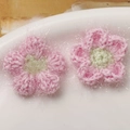 Detailaufnahme der rosa gehäkelten Pufferblumen mit flauschigem Garn und grünem Zentrum - Dunkelrosa