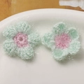 Detailaufnahme handgefertigter Häkelblumen mit Glitzergarn für DIY-Haarschmuckzubehör - Grün