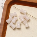 Macro detail of light pink bamboo-shaped gemstone beads with central hole for DIY jewelry - Rose Quartz