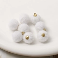 Nahaufnahme von acht weißen Kunstpelz-Pompons mit goldenen Ösen für DIY-Schmuckherstellung - Weiß