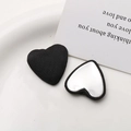 Detailed view of heart-shaped black ribbed fabric buttons with flat silver metal backings - Black