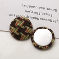 Macro shot of two tweed fabric covered buttons with metallic base for DIY accessories - Yellow Coffee Texture